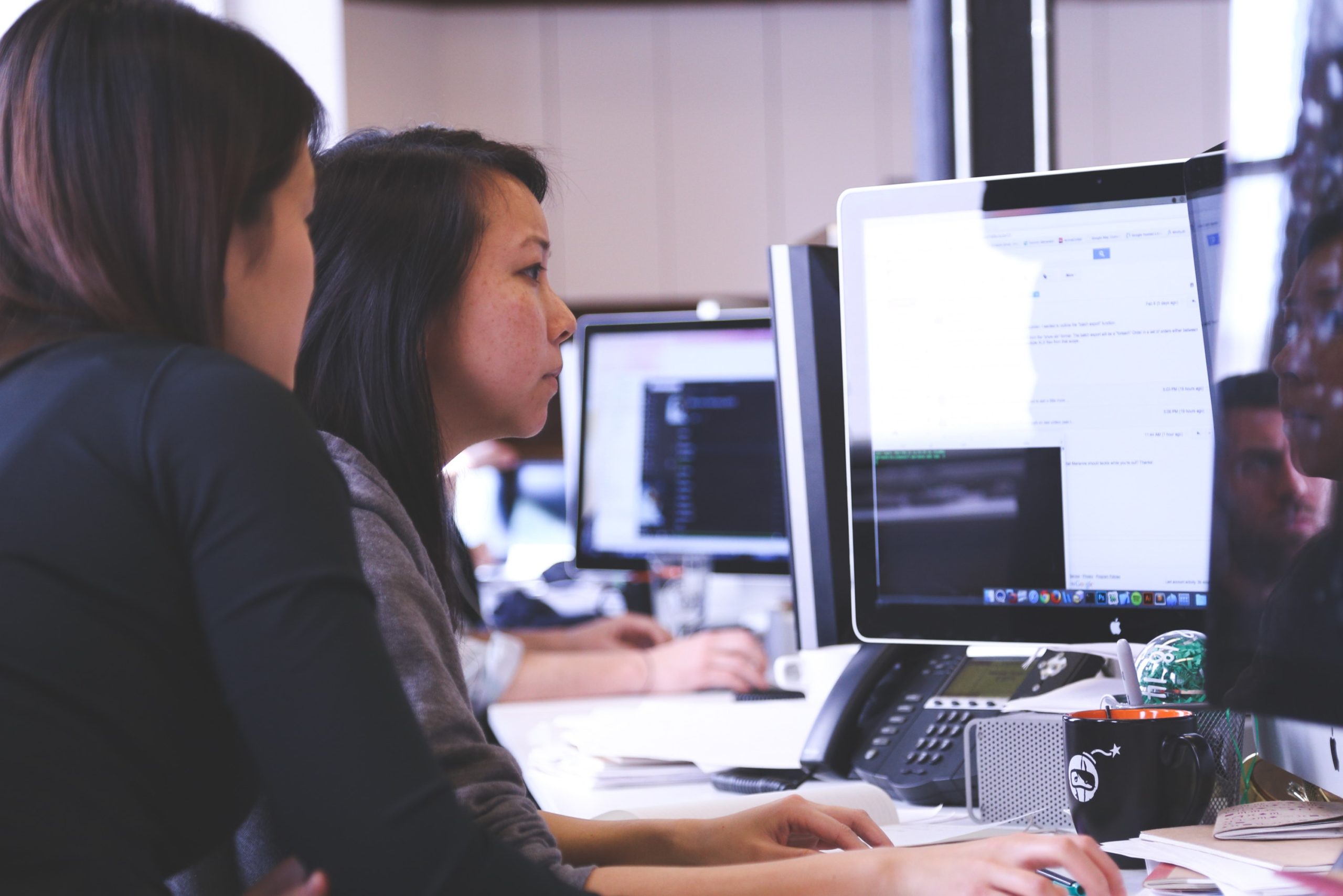 Dos mujeres trabajando en la pantalla del computador